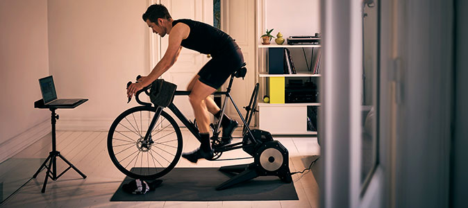 Homem treina ciclismo indoor na sala