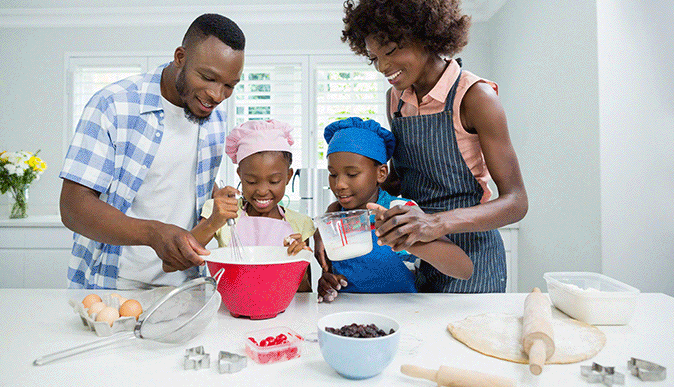 troca de 3 imagens, imagem 1 com uma família composta por pai, mãe e duas crianças na cozinha preparando alimentos, imagem 2 vó cozinhando com neta que quebra um ovo na vasilha, imagem 3: pai e filha cozinhando, pai amassando farinha numa tigela e filha com as mãos sujas de farinha olhando