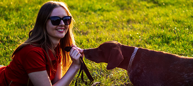 Mulher cega deitada na grama com cão guia