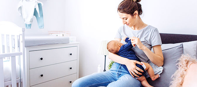 mãe amamenta seu filho em um quarto