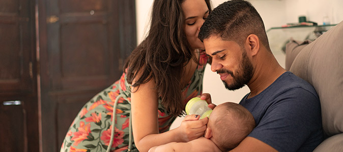 Pai auxiliando na amamentação do bebê