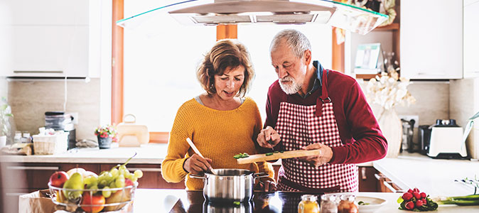 casal idoso cozinhando juntos